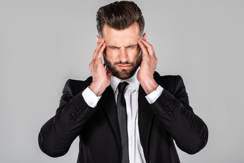 hombre de negocios agotado en traje negro con dolor de cabeza aislado en gris
 - Foto, imagen