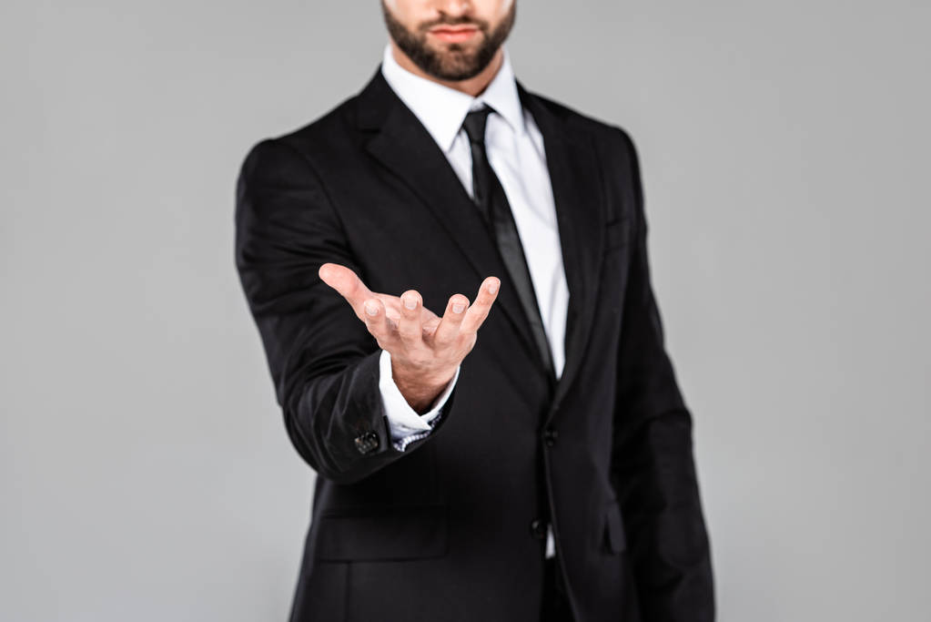vista recortada de hombre de negocios en traje negro con la mano mendicidad aislado en gris
 - Foto, imagen