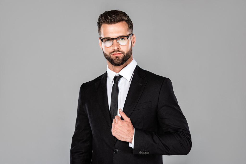 seriöser erfolgreicher Geschäftsmann im schwarzen Anzug und Brille isoliert auf grau - Foto, Bild