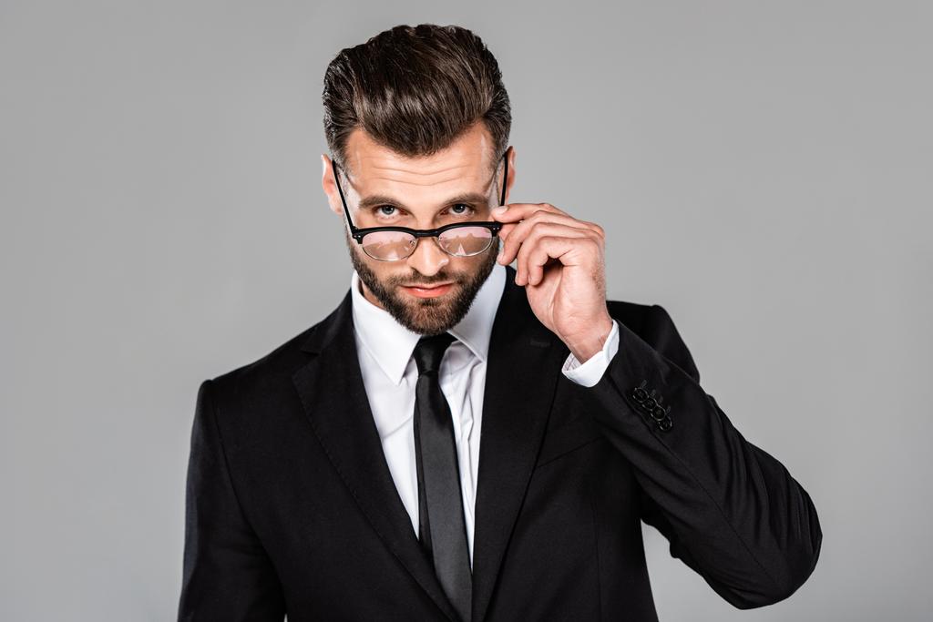 επιτυχημένος επιχειρηματίας με μαύρη στολή και γυαλιά που απομονώθηκαν σε γκρι - Φωτογραφία, εικόνα