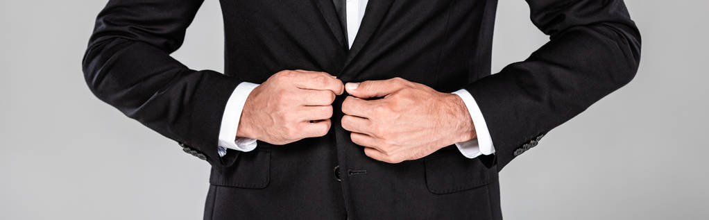 灰色のパノラマショットに隔離された黒いスーツの留めボタンでエレガントなビジネスマンのトリミングビュー - 写真・画像