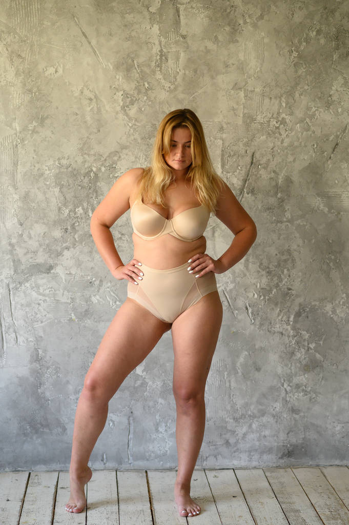 Kaunis ylipainoinen nainen beige uimapuku harmaalla taustalla
 - Valokuva, kuva
