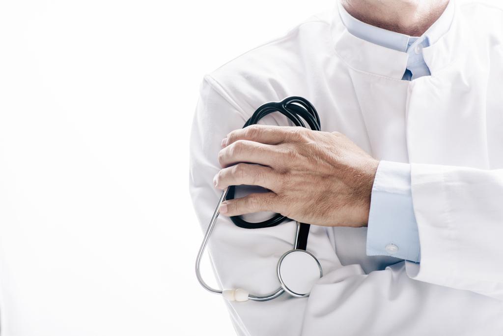 обрізаний вид лікаря в білому пальто, що тримає стетоскоп ізольовано на білому
 - Фото, зображення