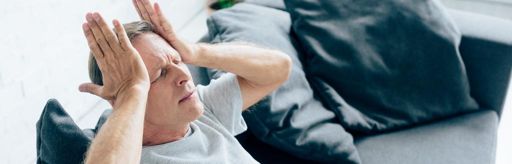 panoramic shot of handsome man with headache in apartment  - Photo, Image