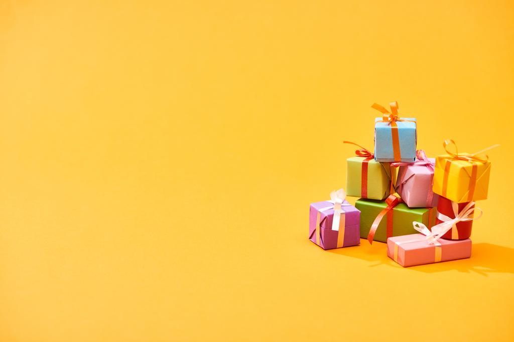 stack of colorful festive boxes on bright orange background - Photo, Image