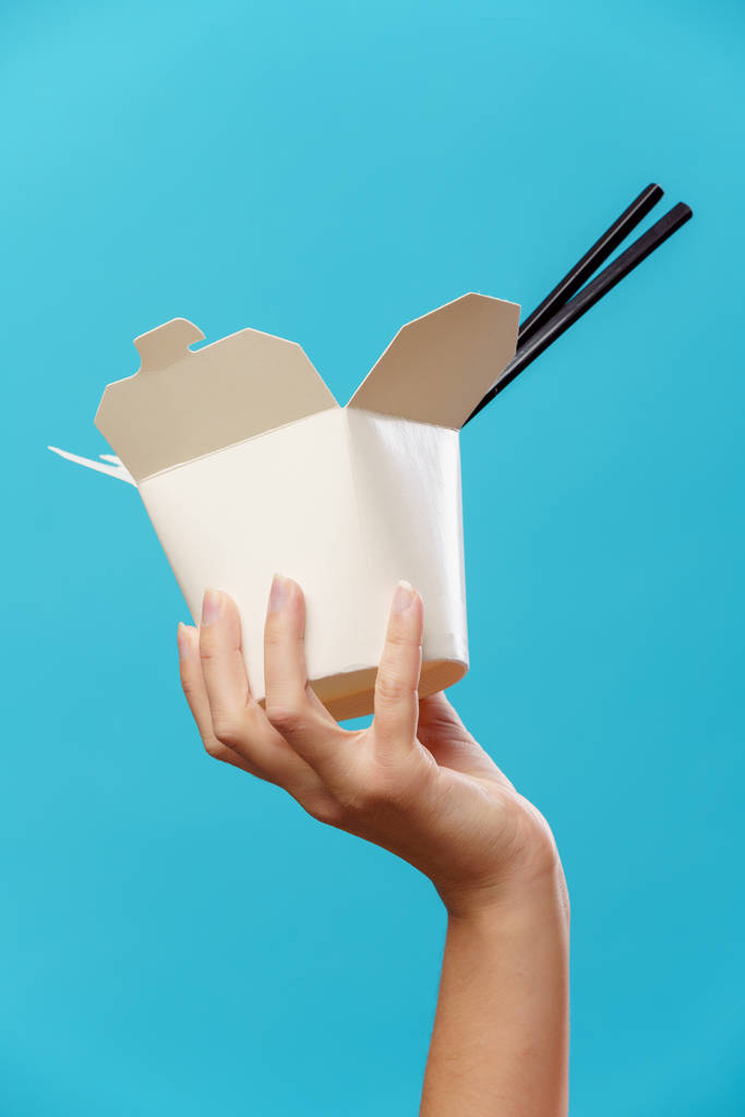 Photo de main avec boîte en carton pour wok, bâtons
 - Photo, image