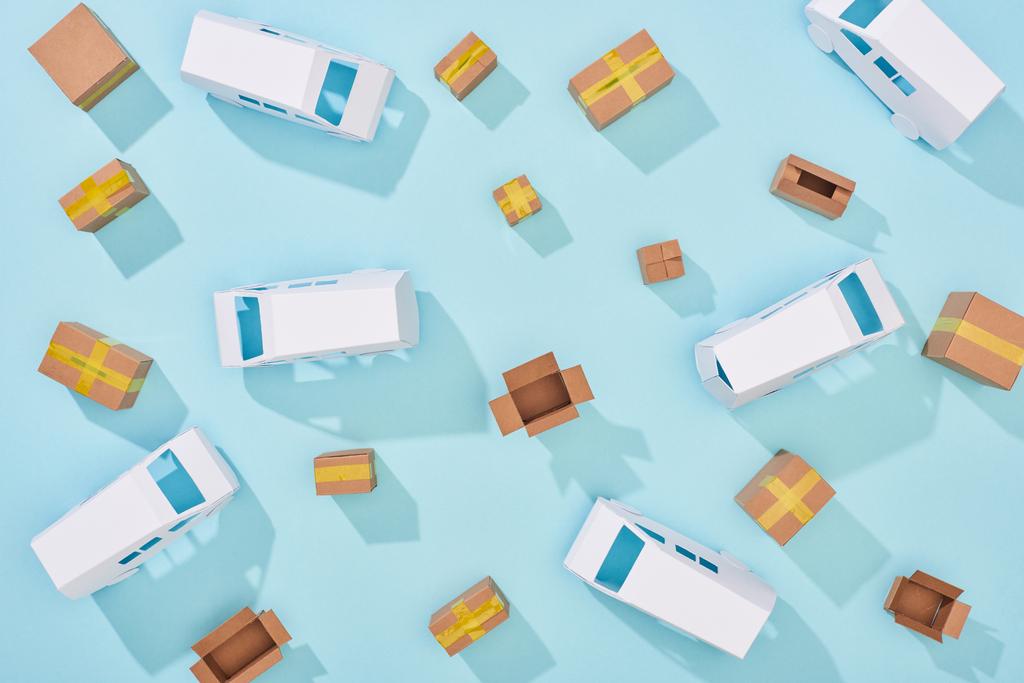 Ansicht von Kartons und Kleintransportern auf blauem Hintergrund - Foto, Bild