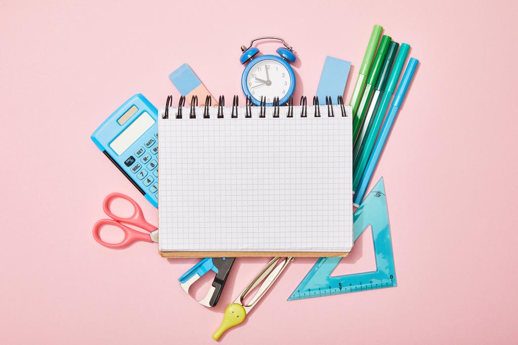 vista superior de los útiles escolares cerca del cuaderno en blanco aislado en rosa
 - Foto, Imagen