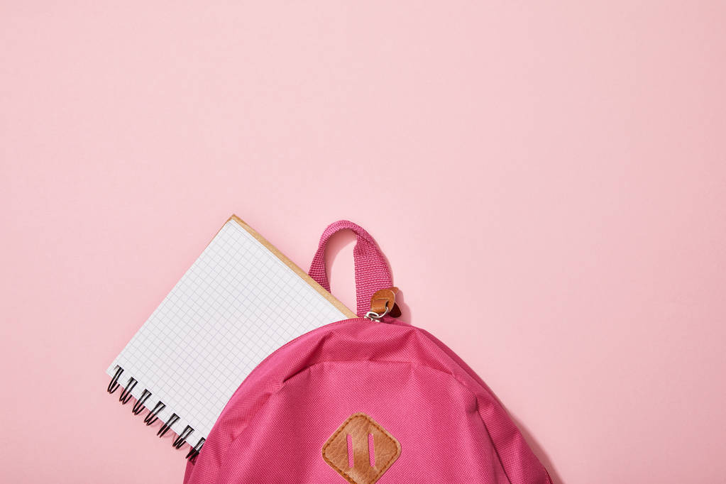 top view of blank notebook near backpack isolated on pink - Photo, Image