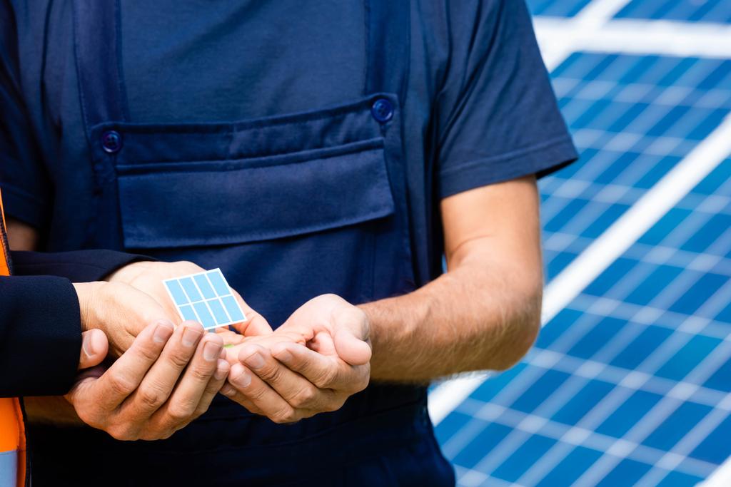 cropped view of engineer and holding solar battery model  - Photo, Image