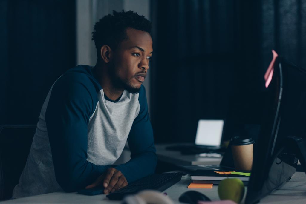 pensativo programador afroamericano que trabaja en la noche en la oficina
 - Foto, Imagen