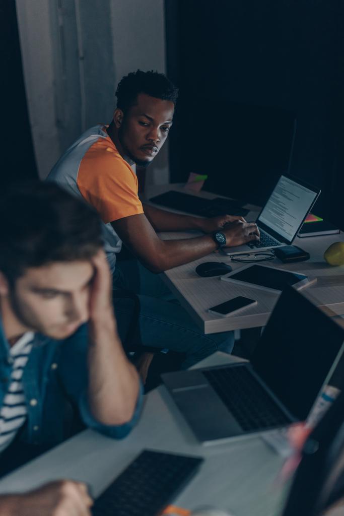 zwei junge multikulturelle Programmierer arbeiten nachts im Büro - Foto, Bild