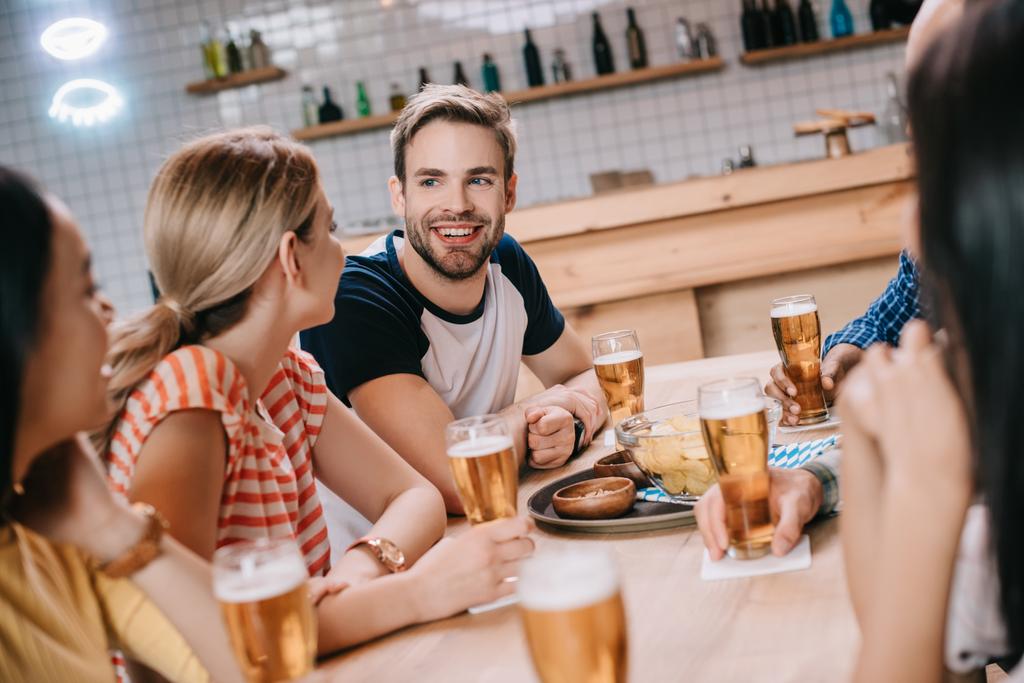 cheerful friends talking while spending time in pub together - Photo, Image