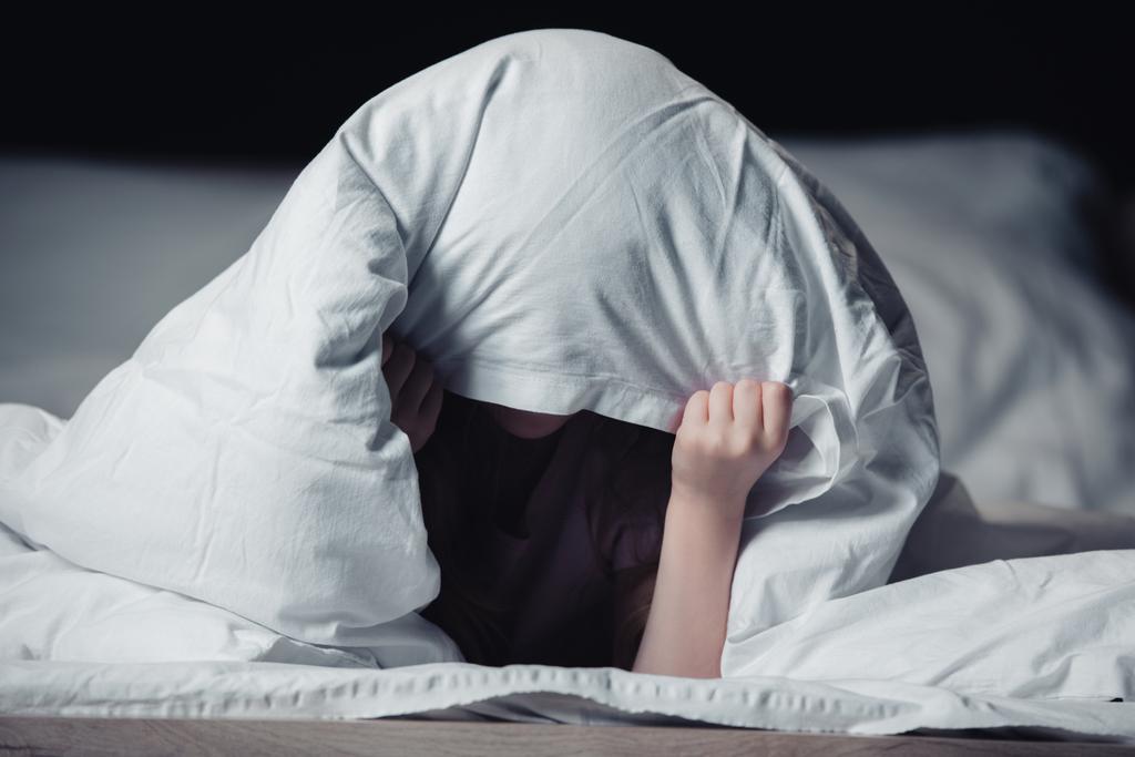 enfant effrayé se cachant sous couverture isolé sur noir
 - Photo, image
