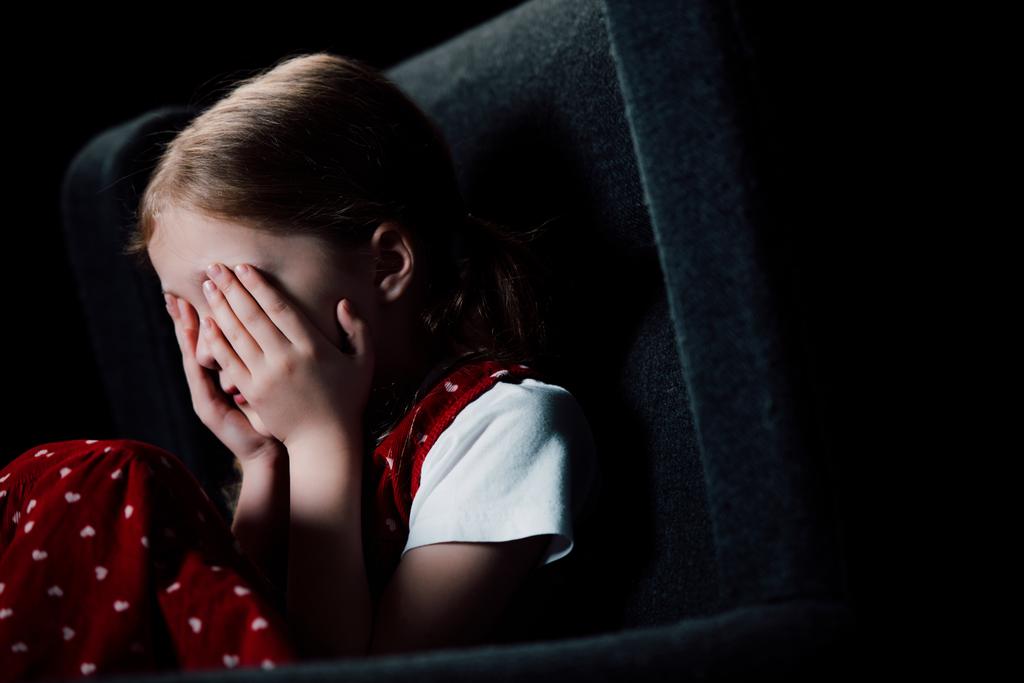 déprimé, effrayé enfant couvrant le visage avec les mains isolées sur noir
 - Photo, image