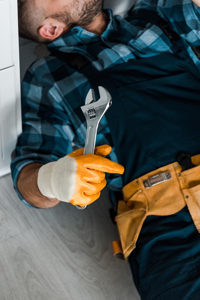 обрезанный вид бородатого работника с регулируемым гаечным ключом во время работы на кухне
  - Фото, изображение
