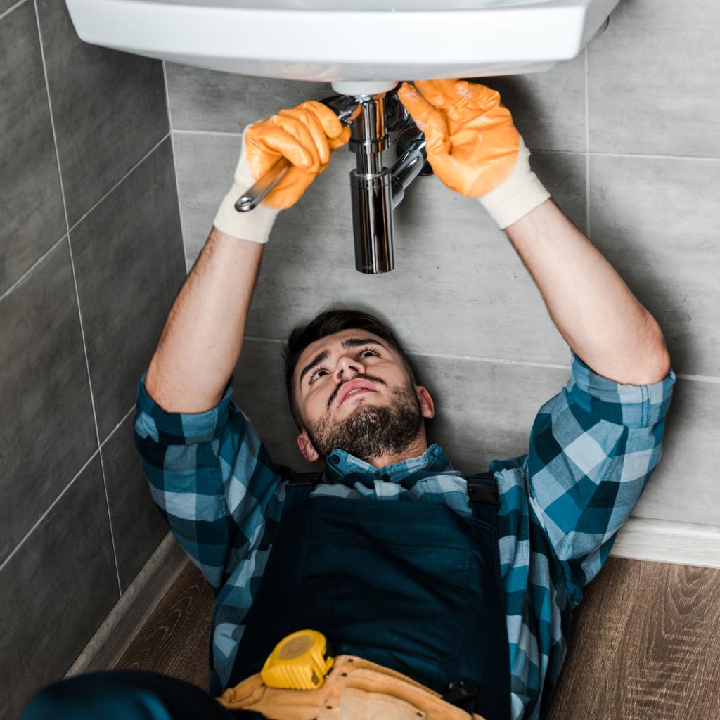 sakallı tamirci banyoda ayarlanabilir anahtarı ile su hasarı sabitleme  - Fotoğraf, Görsel