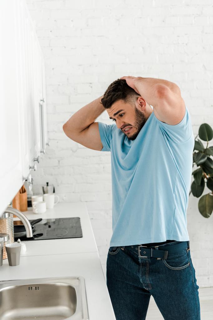 sconvolto uomo toccare la testa mentre guardando lavandino in cucina moderna
  - Foto, immagini