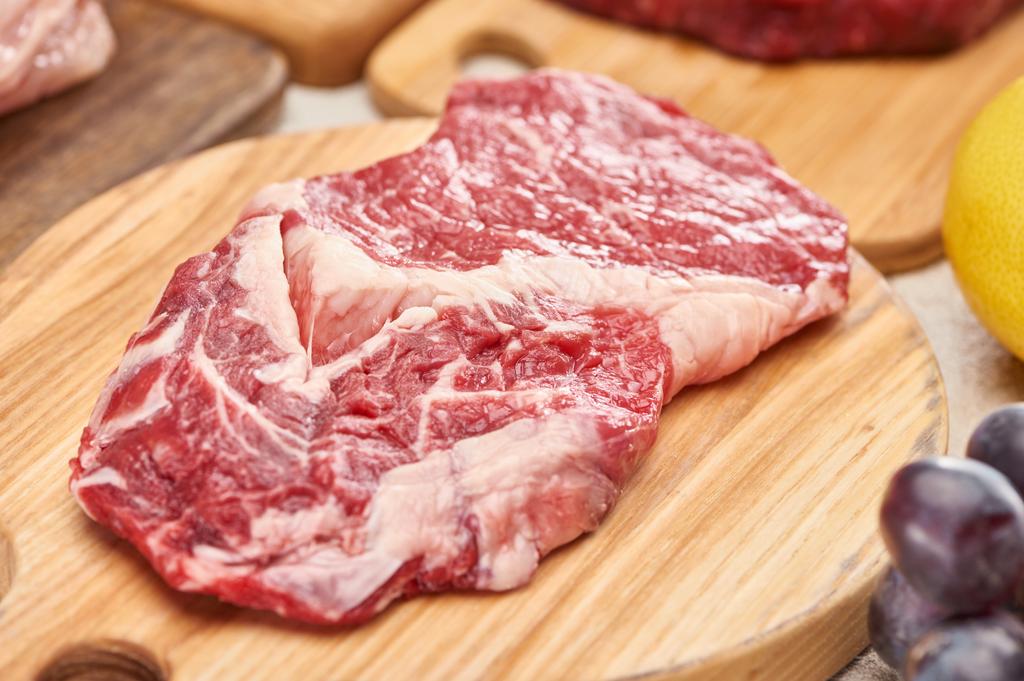 Close up view of raw meat on light wooden cutting board - Photo, Image