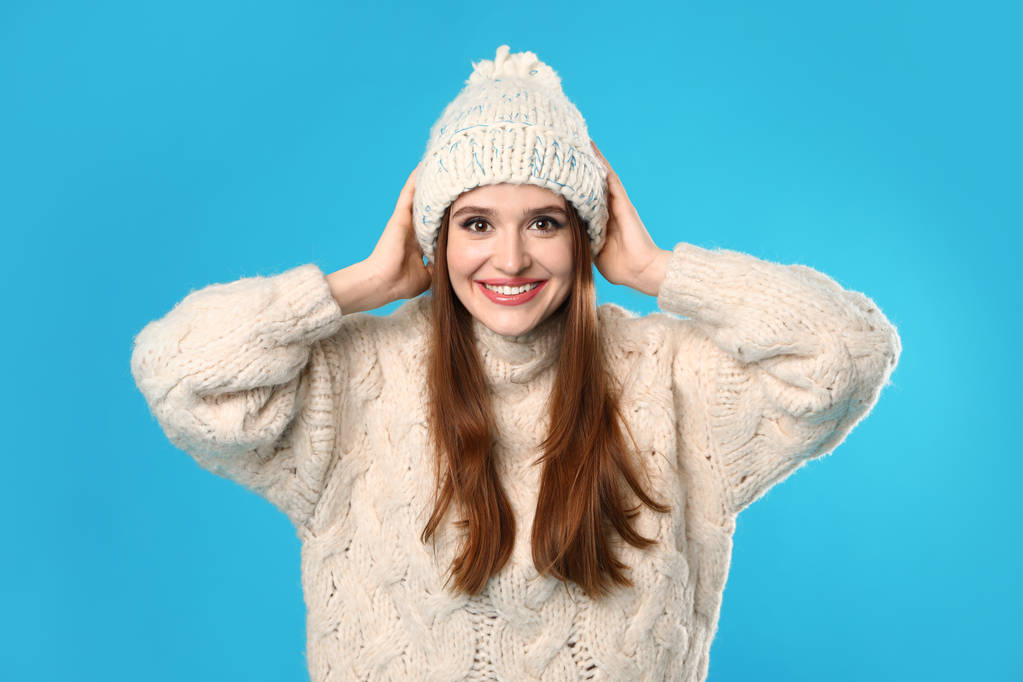Nuori nainen yllään joulun villapaita sinisellä taustalla
 - Valokuva, kuva