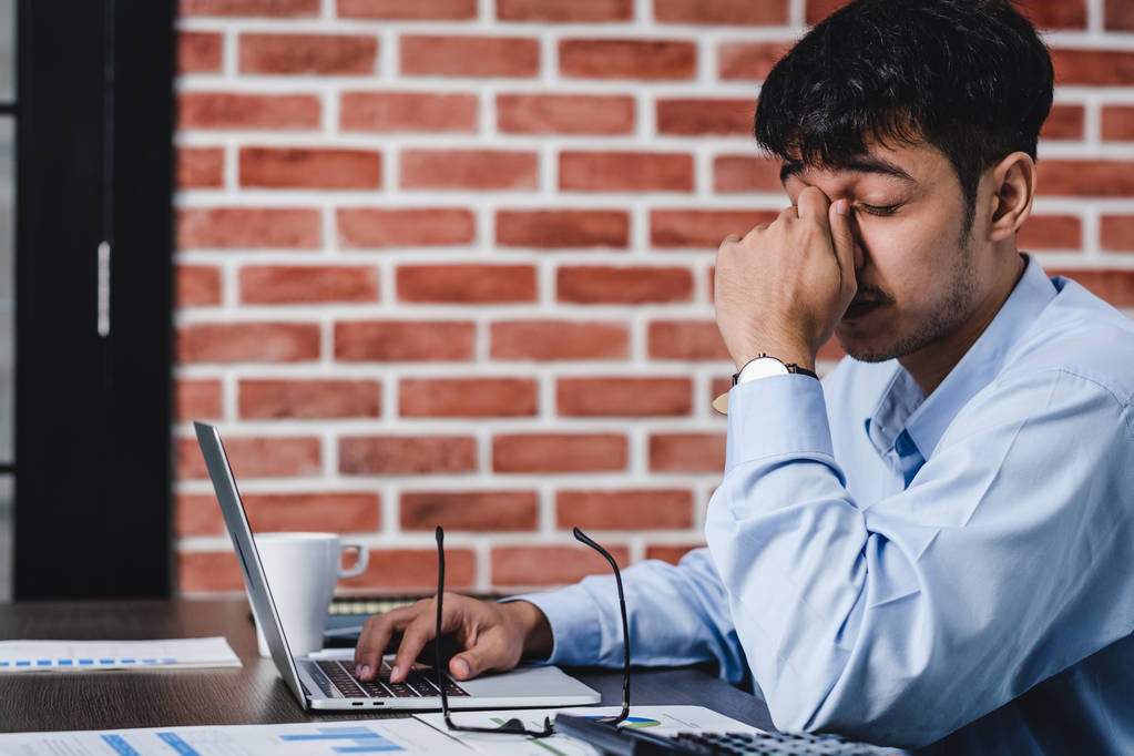 азіатський бізнесмен отримує стрес і головний біль при роботі з ноутбуком
 - Фото, зображення