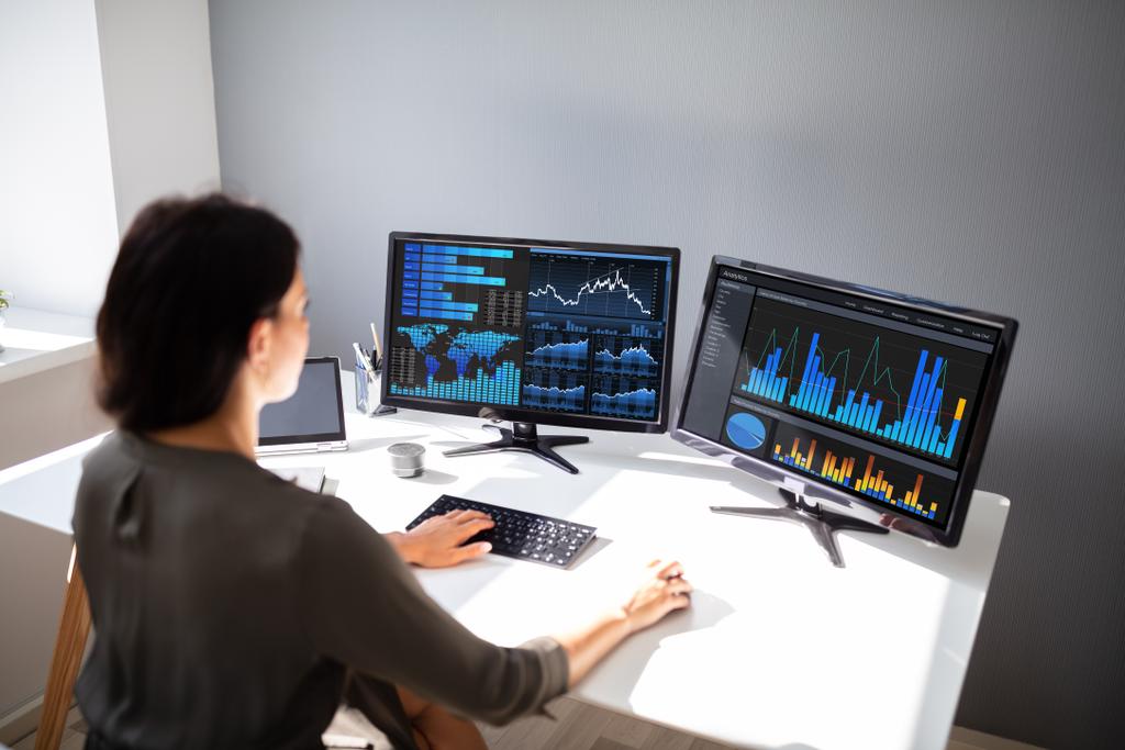 Jovem corretora do mercado de ações feminino analisando gráfico no computador no local de trabalho
 - Foto, Imagem