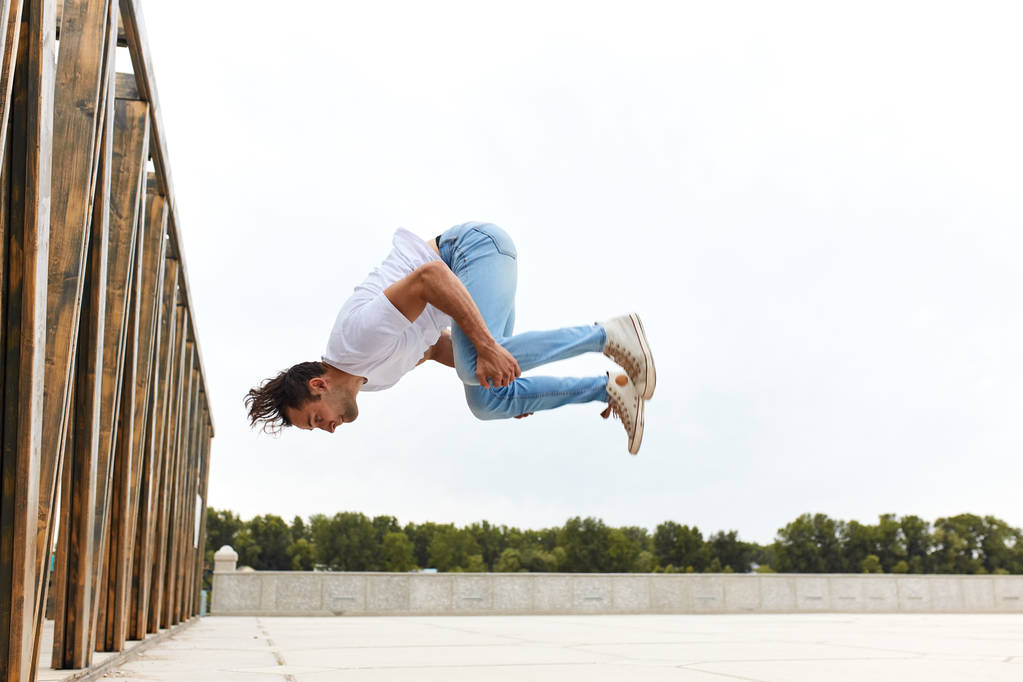 Junger Mann lernt Salto im Freien - Foto, Bild