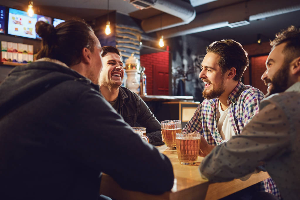 Os amigos falam, bebem cerveja num bar
. - Foto, Imagem