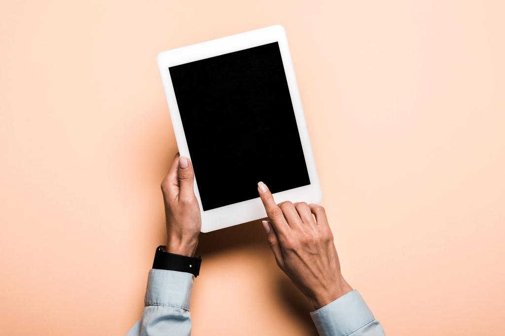 oříznutý pohled ženy ukazujícími prstem na digitálním tabletu s prázdnou obrazovkou na růžovém - Fotografie, Obrázek