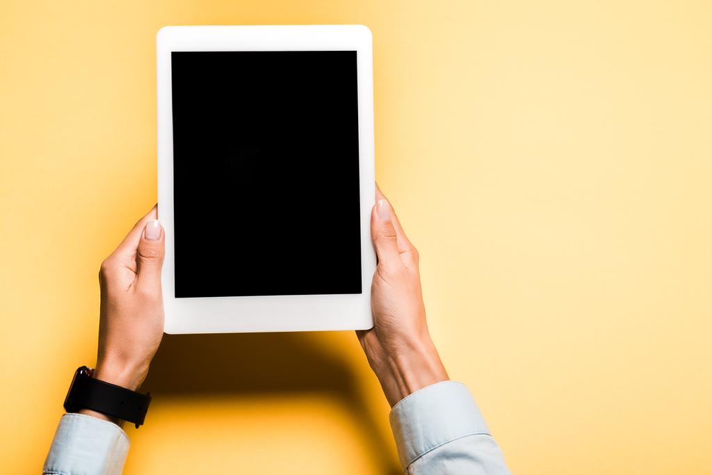 vista ritagliata di donna che tiene tablet digitale con schermo bianco su arancione
  - Foto, immagini