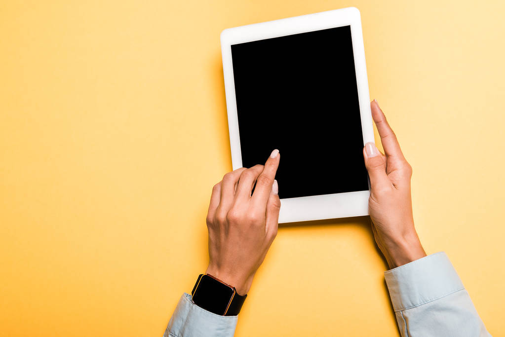 vue recadrée de fille pointant avec le doigt à la tablette numérique avec écran blanc sur orange
  - Photo, image