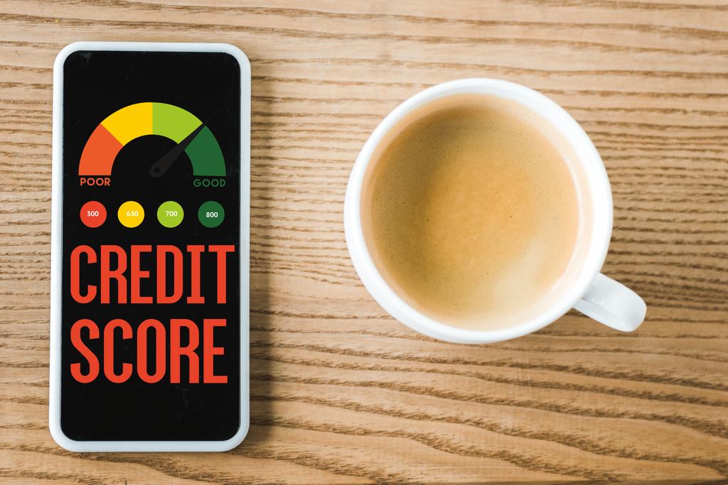 top view of smartphone with credit score lettering on screen near cup of coffee on table  - Photo, Image