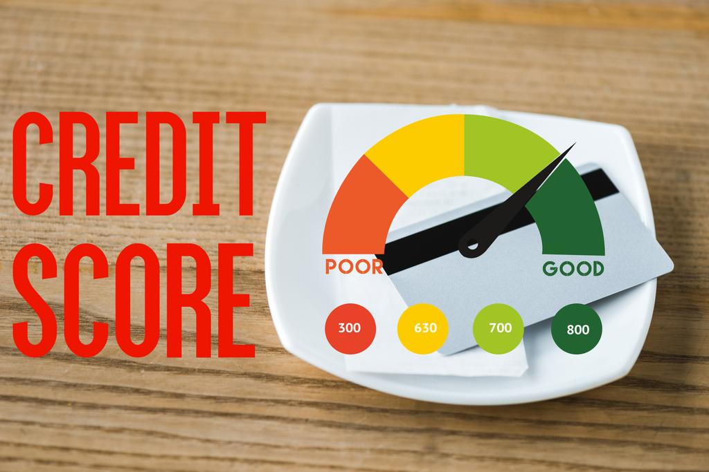 kreditní karta na desce s příjmem a hodnocením kreditu na dřevěném stole  - Fotografie, Obrázek