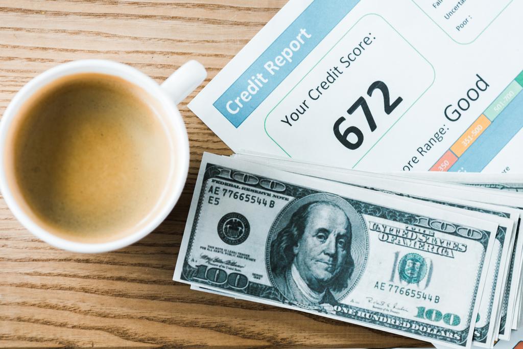 kağıt ve dolar banknotlar üzerinde kredi raporu yazı ile kağıt yakınında kahve ile fincan üst görünümü  - Fotoğraf, Görsel