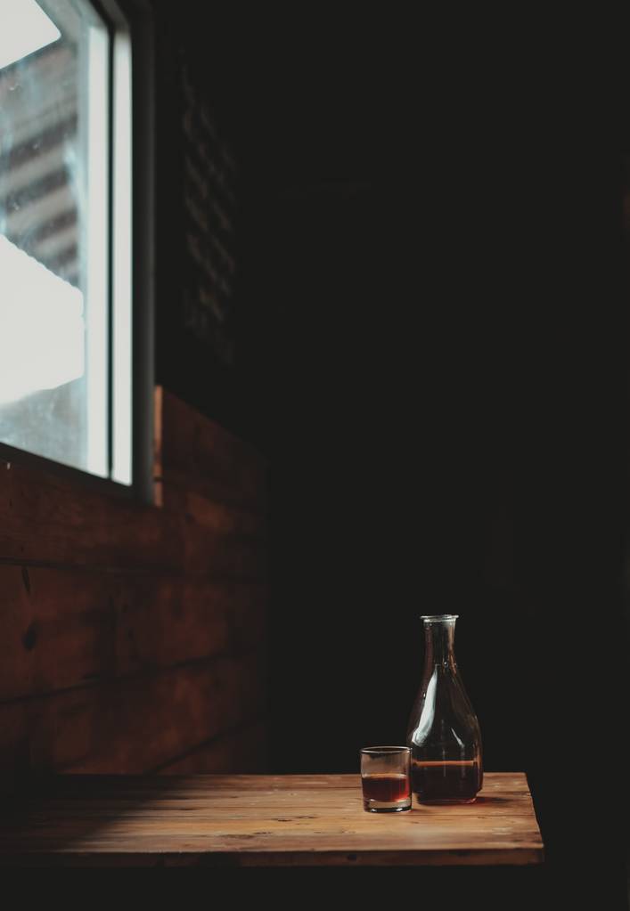 Pullo alkoholipitoisia baverage ikkunan alla
 - Valokuva, kuva