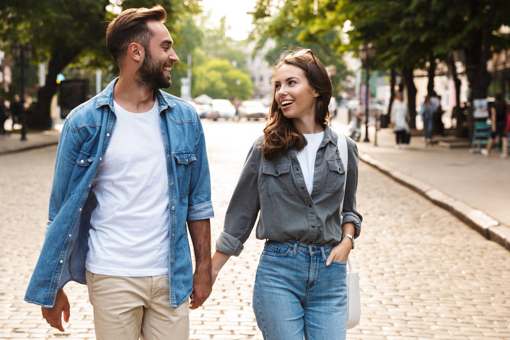 Bella giovane coppia innamorata che cammina all'aperto sulla strada della città - Foto, immagini