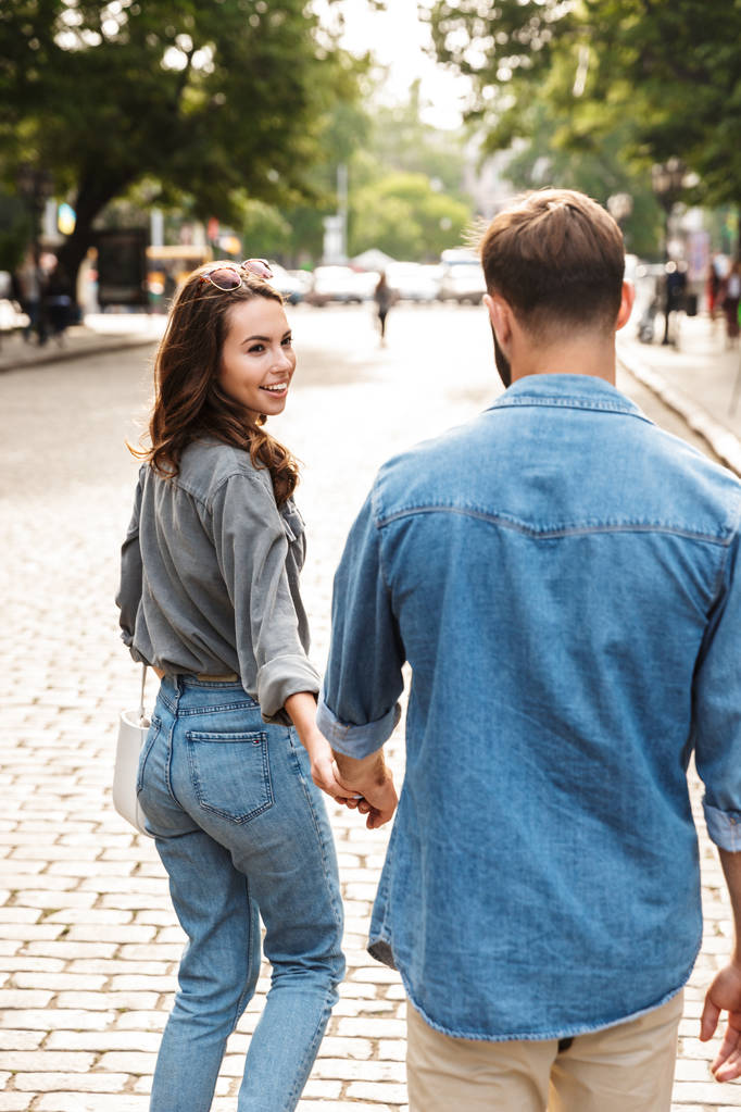 Beau jeune couple amoureux marchant à l'extérieur dans la rue de la ville - Photo, image