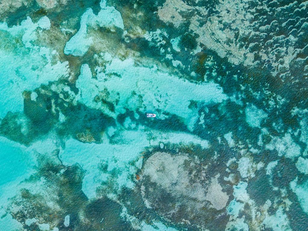 Überkopfschuss eines Bootes in einem welligen blauen Meer - Foto, Bild