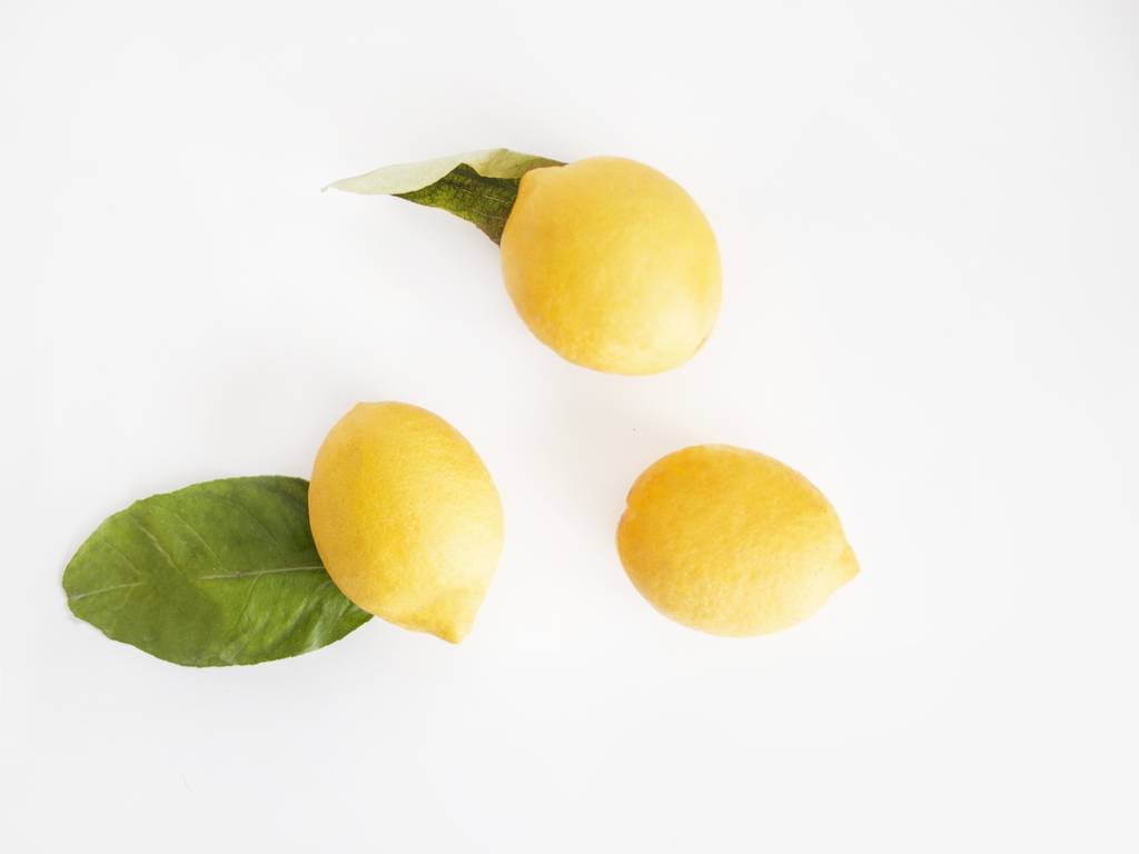 Zbliżenie trzech świeżych cytryny z liśćmi na białym tle - Zdjęcie, obraz