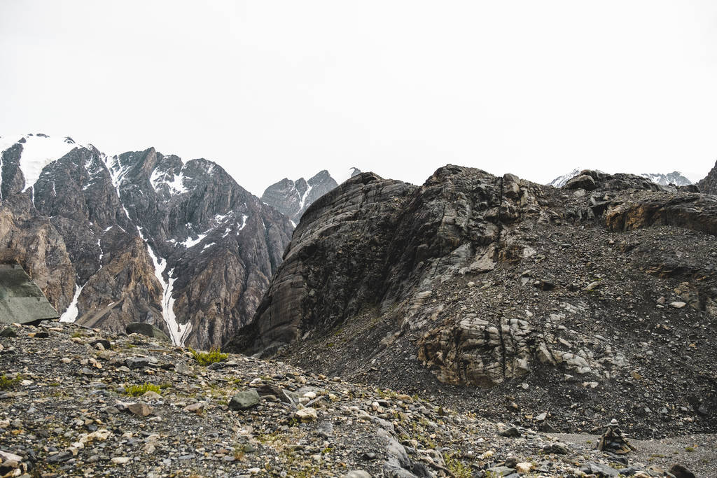 Svahy vysokých zasněžených horských oblastí. Nábřeží mnoha malých kamenů. Krásné výhledy na šplhat, ostré hory na turistickém výletu v přírodě Altajská země.  - Fotografie, Obrázek