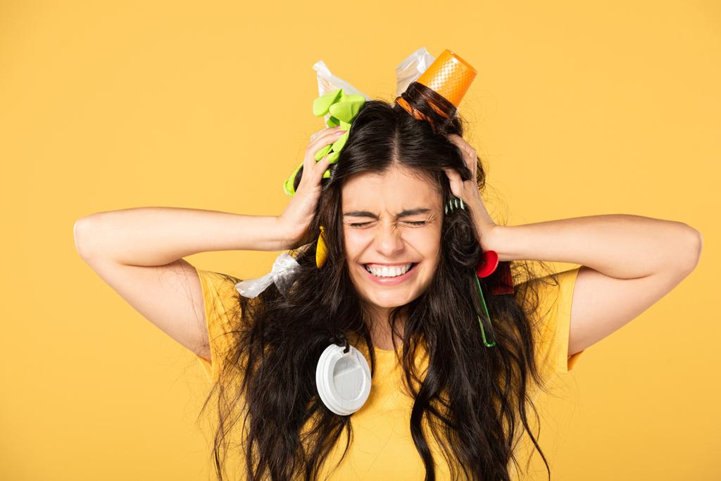 shocked young woman with rubbish in hair isolated on yellow - Photo, Image