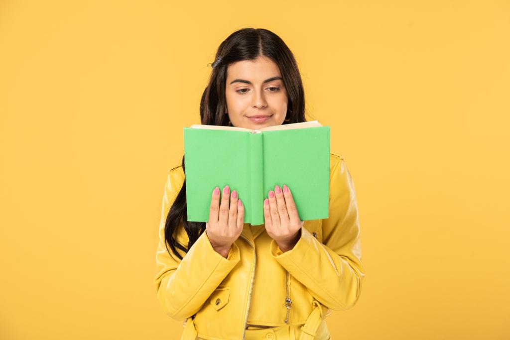 attractive cheerful girl reading book, isolated on yellow  - Photo, Image
