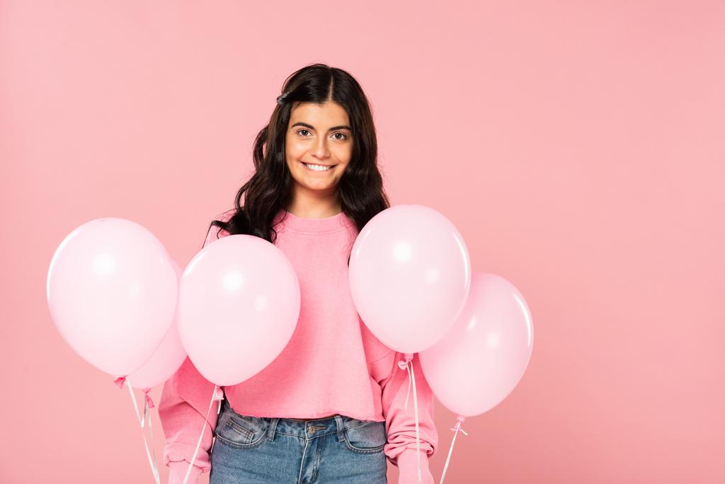 bela mulher sorridente segurando balões rosa, isolado em rosa
 - Foto, Imagem