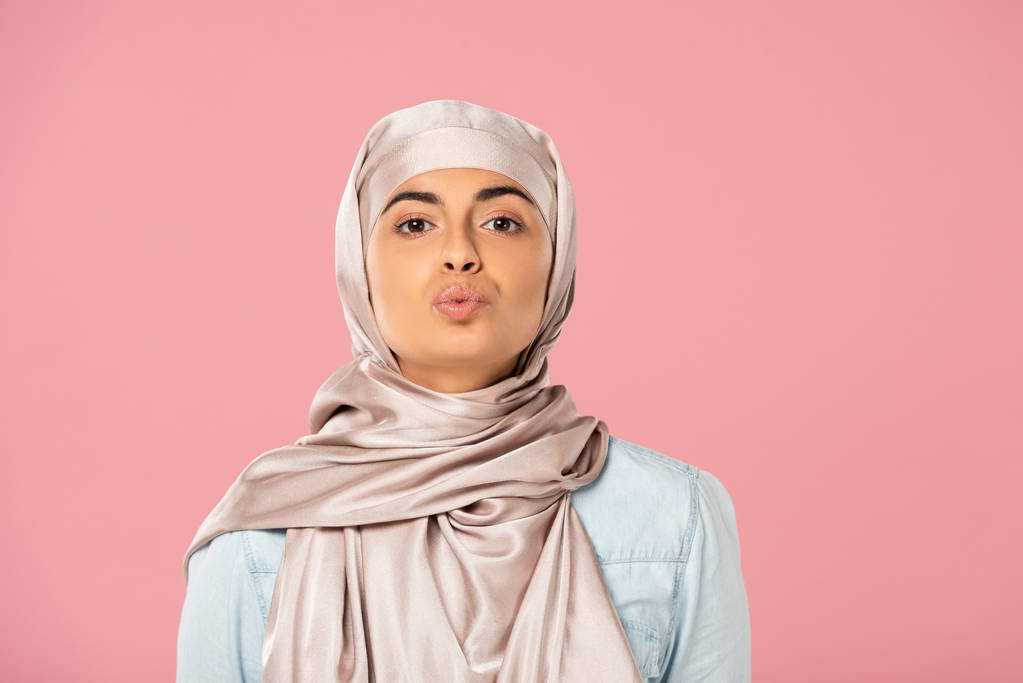 ελκυστικό μουσουλμανικό κορίτσι σε μαντίλα φιλιά απομονωθεί σε ροζ - Φωτογραφία, εικόνα