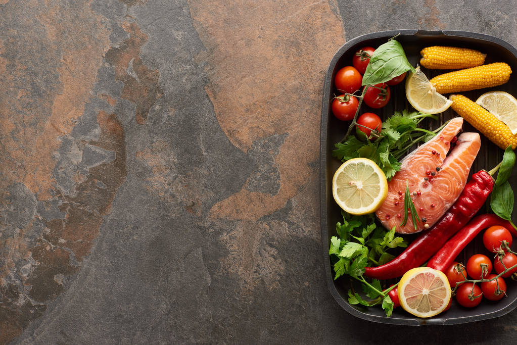 vista superior de salmão fresco cru com legumes, limão e ervas na panela de grelha
 - Foto, Imagem