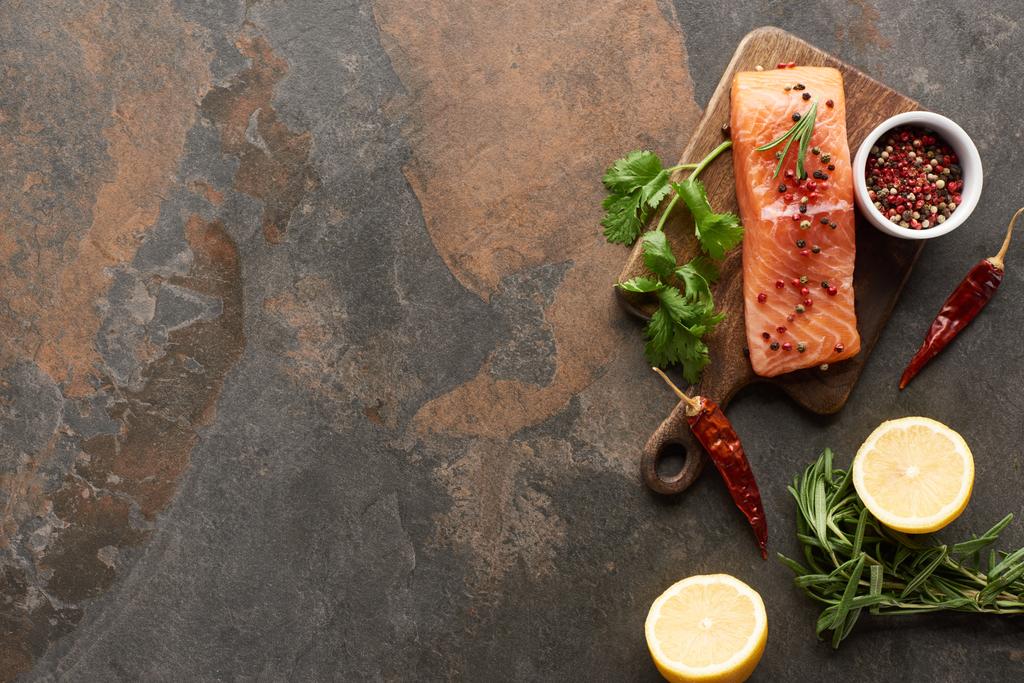 vue du dessus du saumon frais cru avec verdure, piments et citron sur planche à découper en bois
 - Photo, image