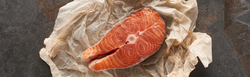 top view of raw salmon steak on bakery paper on stone table, panoramic shot - Photo, Image