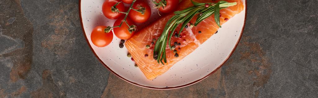 plano panorámico de filete de salmón crudo con tomates, romero y pimienta en el plato
 - Foto, Imagen