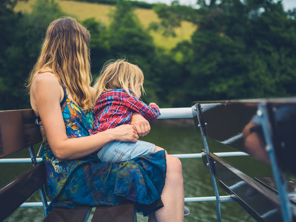 Una giovane madre e il suo bambino stanno navigando lungo il fiume su un traghetto passeggeri
 - Foto, immagini