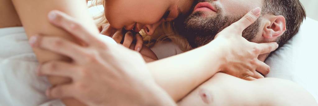 обрезанный вид молодой пары, обнимающейся в постели, панорамный снимок
 - Фото, изображение